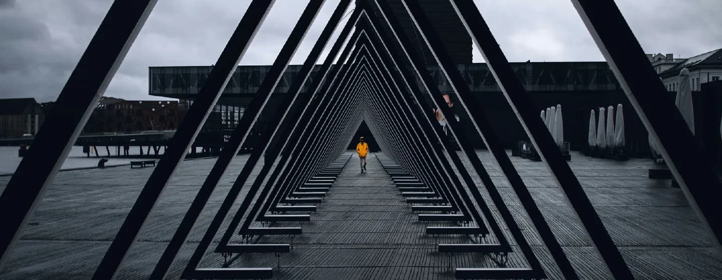 a man stood at the heart of a triangular sculpture symbolising keeping humanity at the heart of insight source triangulation