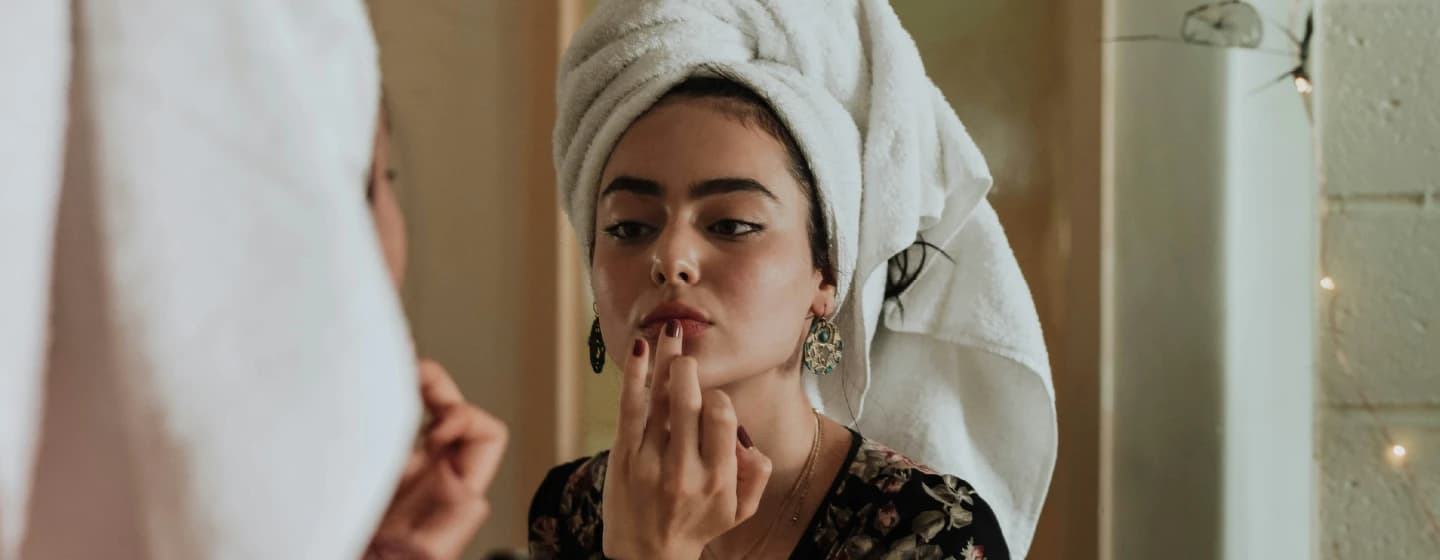 woman doing make up in a mirror